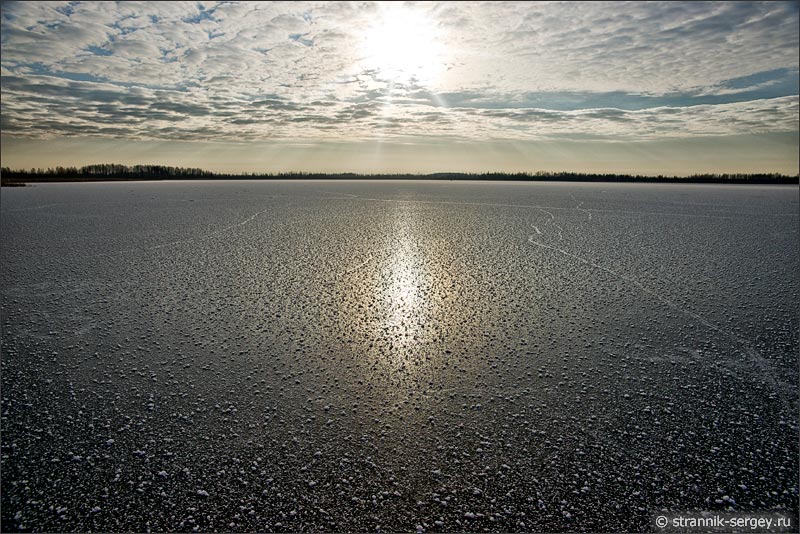 Отражение солнца в замерзшем озере