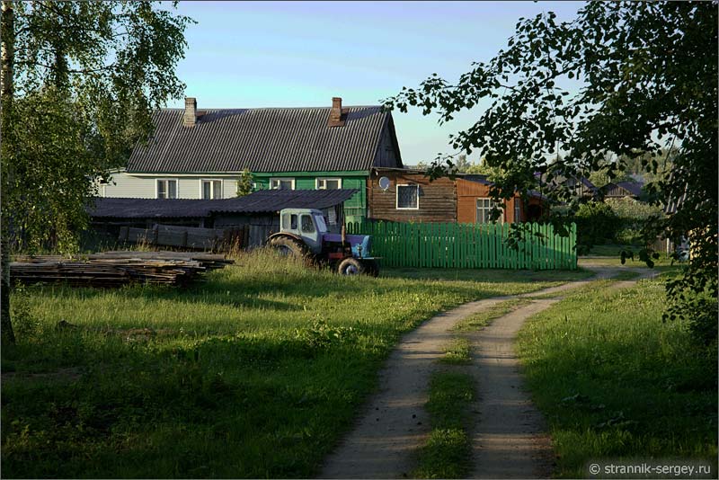 Фото трактора перед домом в деревне